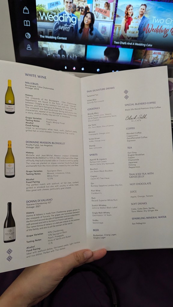 Close-up of Thai Airways business class menu showing white wine selection and drink options.